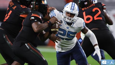 Photo from GoHeels.com - Hart County graduate Kaimon Rucker keeps his eyes on the football as he battles through Miami blockers trying to get to quarterback D’eriq King in Miami on Dec. 12.