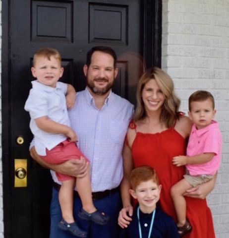 Dan Leard, wife Collen and their kids smile in front of their home.