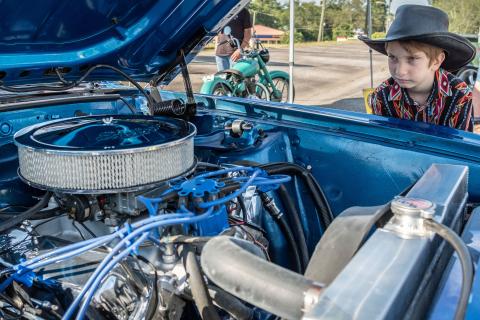 Wyatt Smith (8) admiring the engine of a 1969 Mach 1 Mustang.