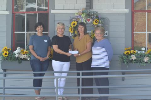 Hart EMC public relations director Angie Brown (center-left) presents a $3,000 check at the Railroad Street train depot to TORCH board members Sharon Morris (left), Kristin Joyner (center right) and TORCH president Mary Gidley (right).