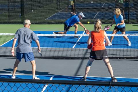 Larry Pizarek lunges for the ball as his partner Pat Pizarek prepares for the return at the Fall Fling pickleball tournament this past weekend.