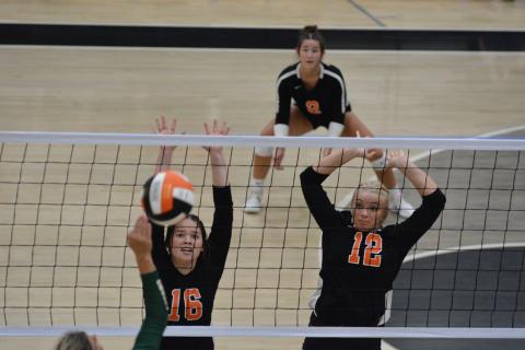 Caitlyn Key (16) and Cali Beebe (12) go up to block the attack.