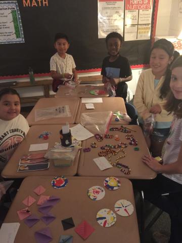 From left to right, students Allie Martinez-Johnson, Jaylen Perez-Rangel, Amonzo Gantt, Maria Benites, and Anna Holmes set up their booths for the Economics Fair at South Hart Elementary School.