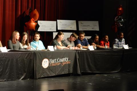 Drew Dotson/The Hartwell Sun From left to right, students Taylor Floyd, Joshua Vaughn and Camarion Verdell sign their scholarships as their proud families look on.