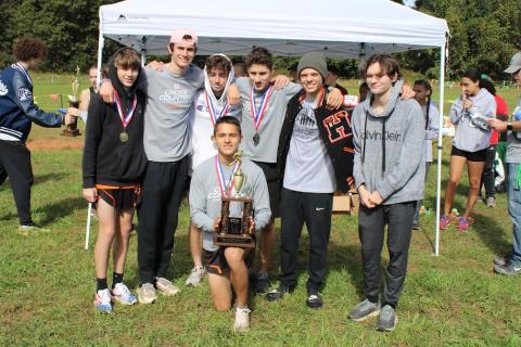 The boys country team pose with their second place trophy after the region meet on Oct. 27.