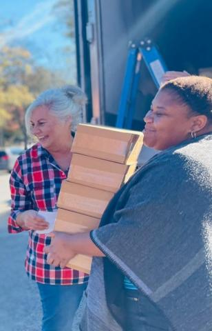 Volunteers Denise Smith, left, and Mariah Clark, right, pack a handful of the 20,000 meals prepared for malnourished peoples in Haiti on Nov. 27 in Lavonia.