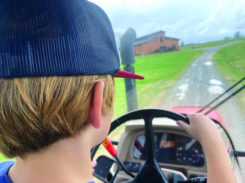 Nine-year-old Bayard, son of Eric and Connell NeSmith, takes us on a ride around the farm in our diesel tractor with an enclosed cab. 