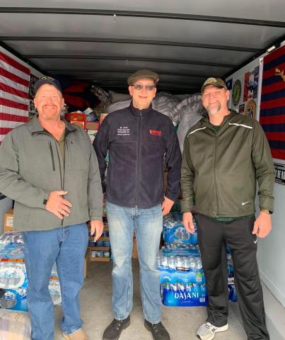 Patrick Wireman (left), a VFW volunteer (center), and Jason Nichols (right) help load supplies in Wireman’s trailer for tornado victims in Ky. 