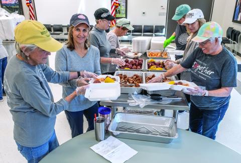 Kate Kirby, Brigid Richardson, Marylynn Johnson prepare plates for drive-through customers. 