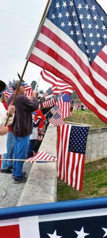 Hart County residents show their support for the convoy by waving Ole Glory.