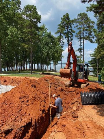 Sidney Skelton and crew members prepare the ground to install a new septic tank.