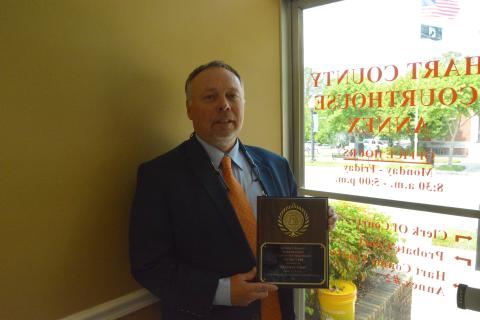 Hart County Clerk of Court Frankie Gray stands proudly with his award inside his office. 