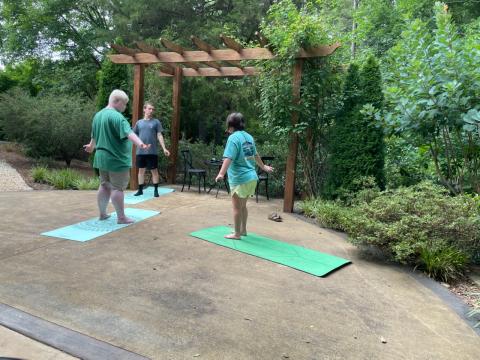 Yoga instructor Briana Kay (right) leads Jake Mitchell (left) and Justin Temples (center) in a yoga session at the Hart County Botanical Garden pavillion.