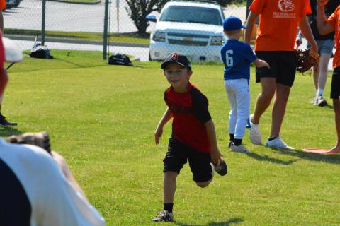 Rhett McGowen runs to first after getting a hit at baseball camp last summer. 