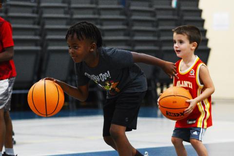Corbyn White (left) and Korbin Cawthon, the youngest camper, work on their dribbling skills in a game of red light, green light. 