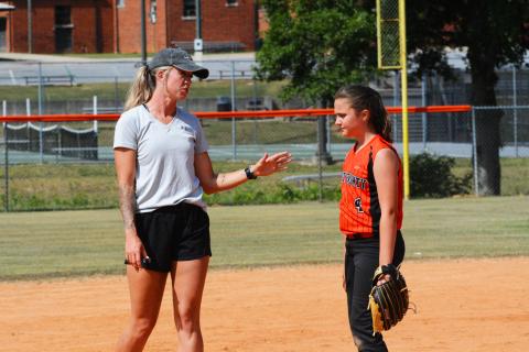 HCMS coach Kim Thomas gives EmmaKate White some pointers to improve her pitching.