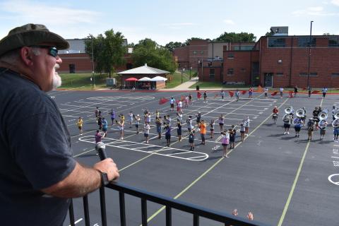 Hart County Band Director Alan Tolbert helps the Bulldog Band set drill from his tower in the high school parking lot. The show has been going on rather quickly this year, according to band leadership. 