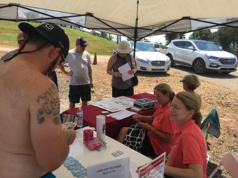 Photo of last year's Pontoon Poker Run with Hart Humane Society dealing a poker hand with an excited participant.