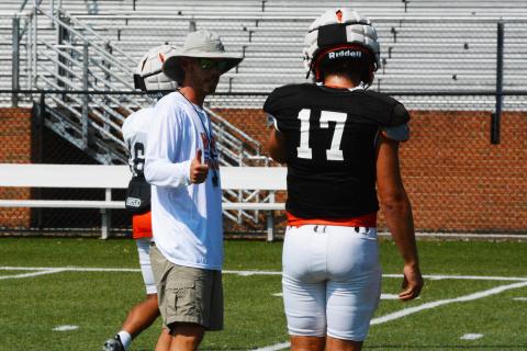 Caleb Sorrells coaches up quarterback Austen Whitworth at practice.