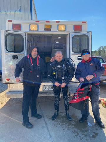 Kinsey Craft (center) poses for a picture fresh from a diving exercise alongside his fellow firefighters Jason Hawley (left) and James David (right). 