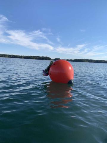 An unknown visitor attached a memorial bouquet Tuesday to the buoy that marks the spot of which a single-engine plane entered Lake Hartwell on Saturday, Sept. 10. The plane was still underwater by press time Wednesday. One passenger, the pilot, was assumed dead upon impact. Excavation crews were scheduled to lift the plane from the lake depths Thursday.