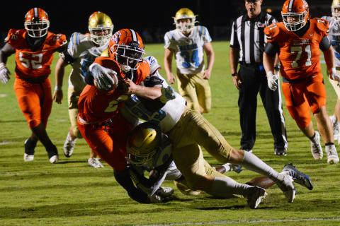 Paul Davis extends the ball over the goal line as multiple Daniel defenders try to bring him down. 