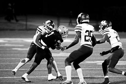 Junior running back Nori Moore attempts to shed the tackle of a Purple Hurricane defender in a tough region loss, 49-14.