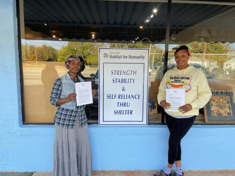 Hartwell residents Rebecca Durrett, left, and Brittany Harland, right, pose with their initial partner family agreement certificate with Hart County Habitat for Humanity building. Durrett and Harland were selected among several applicants for the newest home builds. 