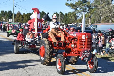 A gentleman takes his tractor along Montevideo Road Sunday at the annual Montevideo Christmas parade. 