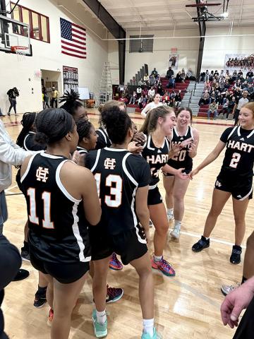 The Lady Dogs basketball team swarm their teammate Phillips in the aftermath of her high school scoring achievement.  