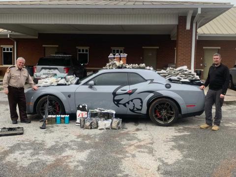 Hart County Sheriff Mike Cleveland (left) and Capt. Chris Carroll stand with the seized “Jail Break Hell Cat” Dodge Challenger, drugs and weapons.