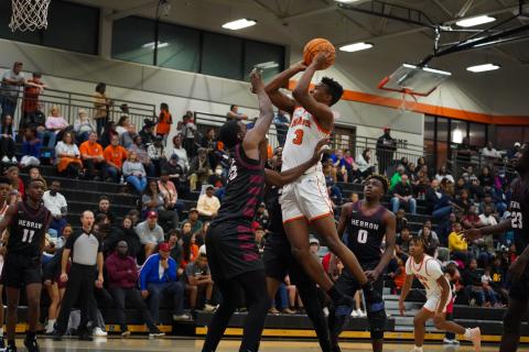 Senior forward Tahj Johnson puts up an acrobatic shot over the defender in the 55-50 home loss to Hebron Christian. Photo taken by Lexie Wheless.