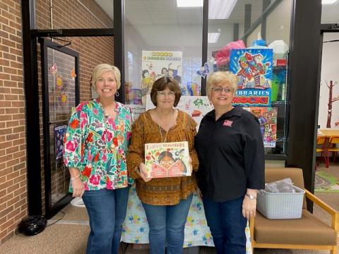 Hart County Farm Bureau Office Manager Tina Simmons, right, and  Hart EMC, Angie Brown, left, recently presented a copy of the children’s ag book “I Love Strawberries” to Pam Cole who accepts the book for the Hart County Public Library. The donation was made on behalf of the Georgia Foundation for Agriculture and Georgia EMC. 