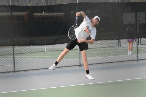 Senior Daniel Leard serves to a Franklin County Lion in Monday’s home match as the boys fell 5-0 and the girls won 3-2.
