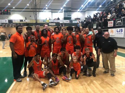The Hart County boys basketball team holding up eight fingers as they upset Adairsville on the road 68-60 to advance to the elite eight in the Georgia High School boys basketball state tournament.