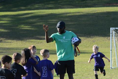 Bell Family YMCA’s sports director Kurve Augustine coaching up a 5U soccer team during a game on Tuesday.