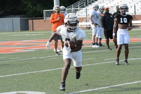 Rising senior running back Nori Moore looks to turn up the field in Monday’s spring practice .