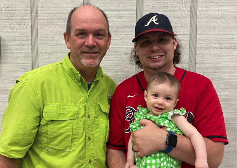 Todd London (left) stands next to his son Benjamin London (right), who is holding a very happy Baylor Kate. 