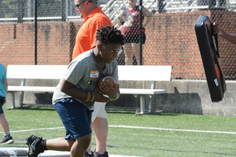 Pictured is Brydon Martin as he tucks the ball and prepares for contact in a running back drill during the camp in 2022. 