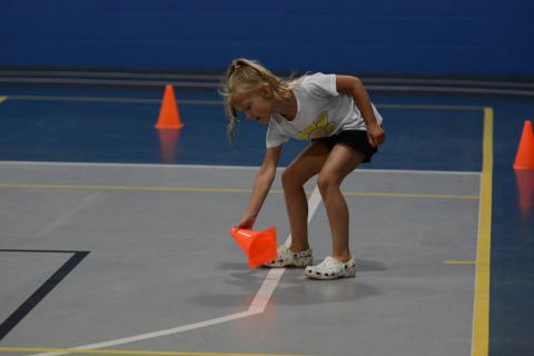 Layla Reagin plays in a game to help work out the core during the YMCA Kids Fit Camp.