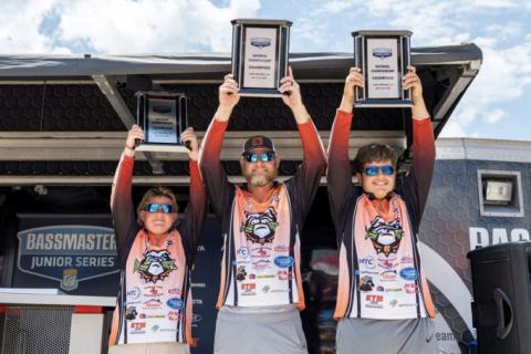Pictured from left to right Kale Temple, boat captain Isaac Temple, and Luke Schnell hoisting up their Bassmaster Junior National Championship trophies during the awards ceremony on  Saturday, July 22 on Lake Hartwell. They also received a $2,000 scholarship during the ceremony as well. (Photo by Logan Crumley, Bassmaster)