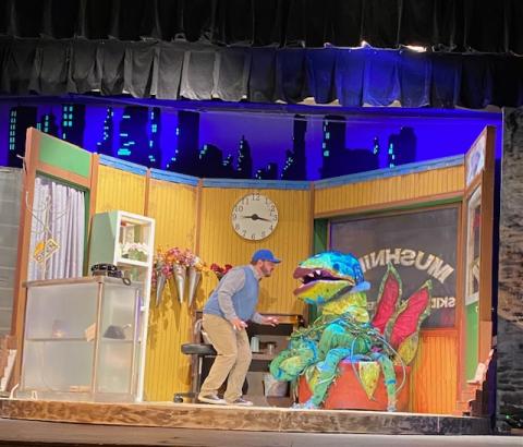 Actor Ethan Smith as Seymour speaks to Audrey II controlled by puppeteer Elna Brynestad.