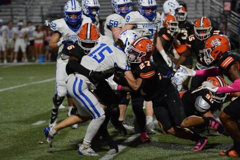 Jamir Rucker (6) and Tay Martin (27) tackle the Warriors quarterback in the 27-16 win.