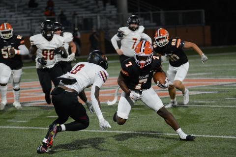 Senior running back Nori Moore attempts to juke the oncoming Hebron Christian defender in the 27-0 loss on Oct. 27.