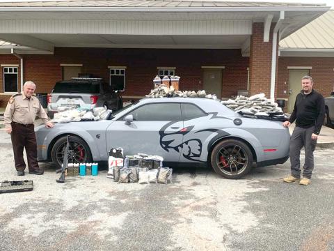 Hart County Sheriff Mike Cleveland (left) and Capt. Chris Carroll stand with the seized “Jail Break Hell Cat” Dodge Challenger, drugs and weapons. The Jan. 17 incident comes in at number six on our list. 