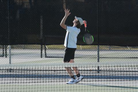 Senior No. 1 singles Justin Mooney prepares to serve the ball during the 2023 season. 