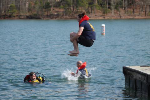 Grayson Williams makes a cannonball during the 28th Polar Plunge March  2 at Lake Hartwell. Williams and Mike Baier represented the Hartwell Rotary club while Hart County EMT Jason Hailey looks on. Photo by Holly and Honeysuckle Co.