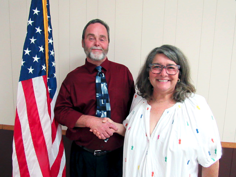Bowersville Mayor John Smith shakes hands with Dee Schwarzmann after her first meeting on the city council.