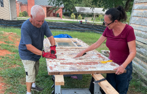 Lori Smith and her father, Richard, scraping paint off the front door from an E. Howell St. historic house last year.