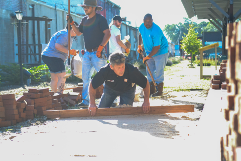 Hartwell Home Depot manager Jeff Meitz (center left) and staff members Katherine Alewine, Jennifer Hill, Angela Zimmerman, Gavin Dutton, Chris Parr, Zack Mattox, Teresa Hoover, and Britt Dyar help  to repair an uneven brick walkway at Railroad Street Park.